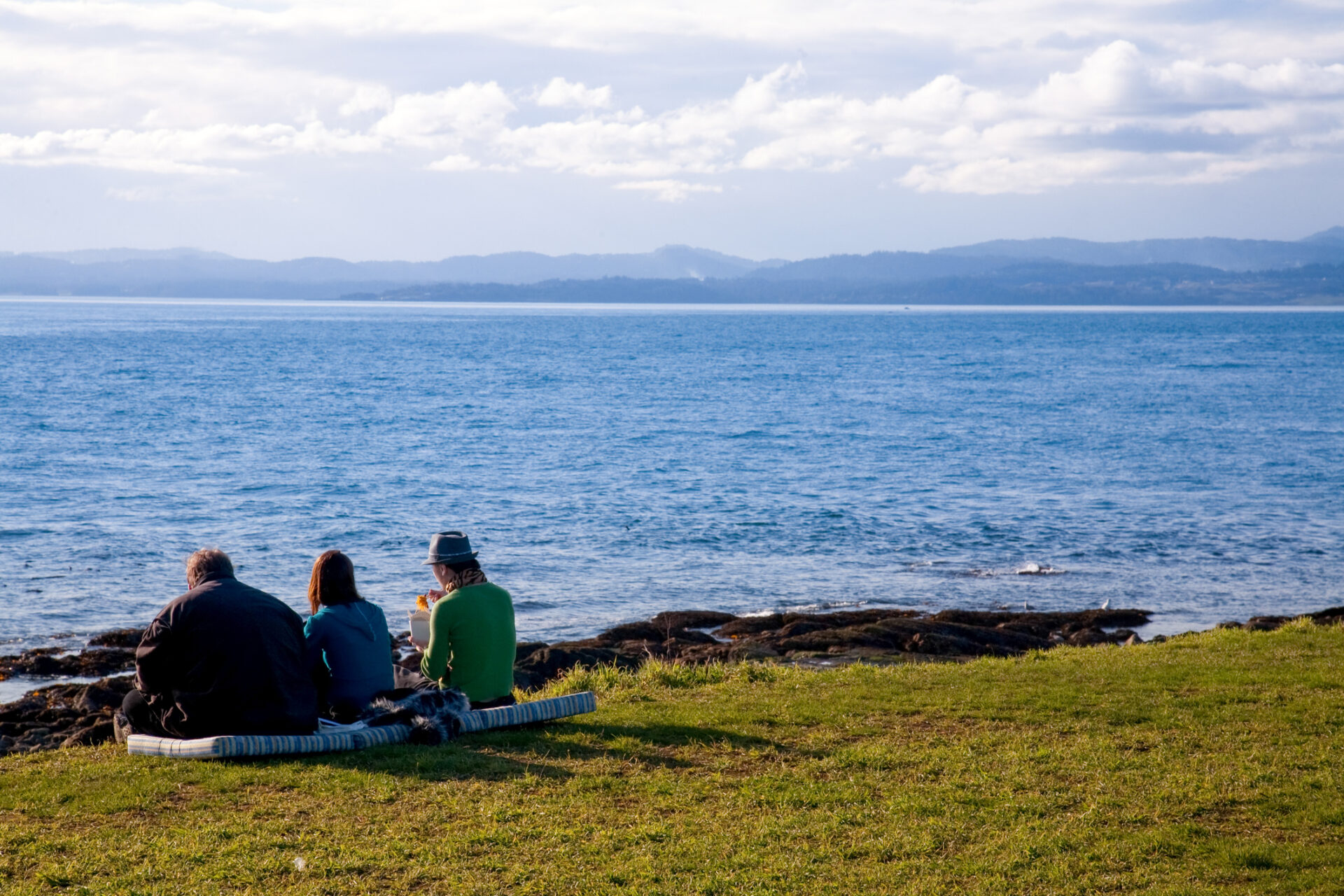 Friends having lunch on beach at Clover Point, Victoria, Vancouver Island, British Columbia. Photo by dbstockphoto on iStock.