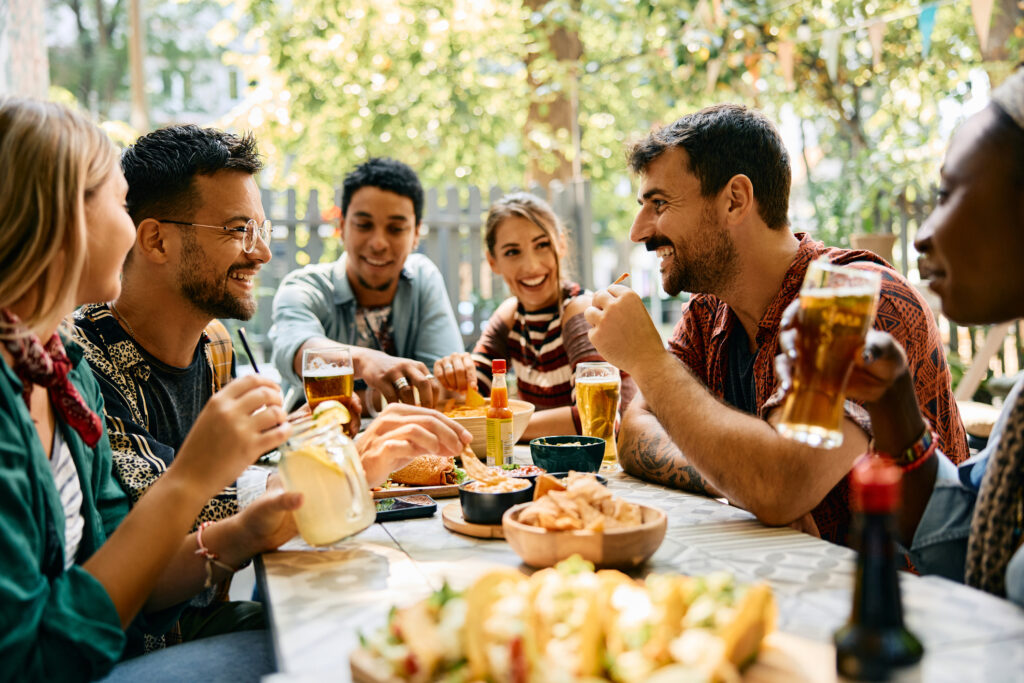 Group of young happy friends talking while gathering in a restaurant.